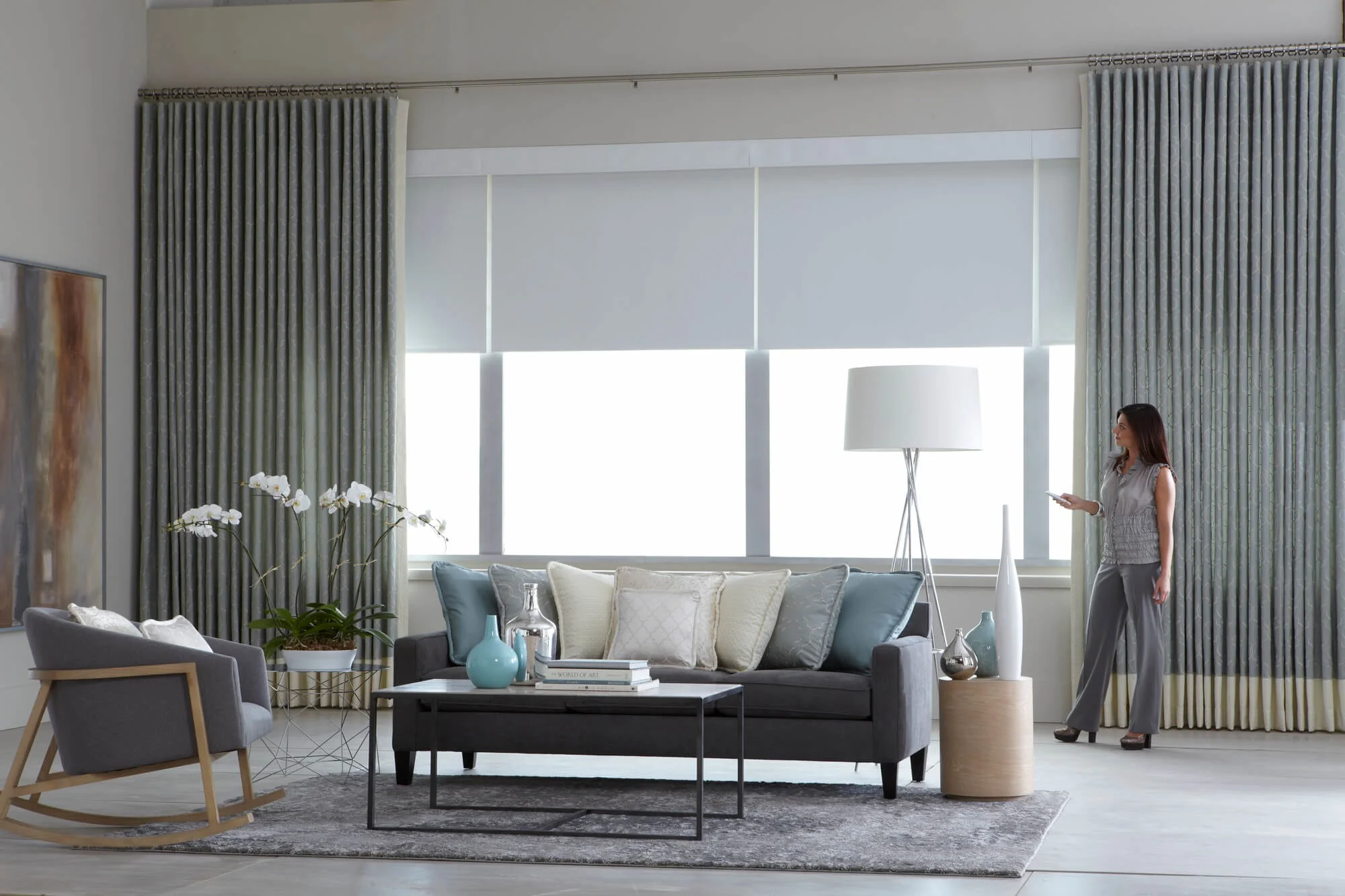 Elegant living room with motorized roller shades and drapes
